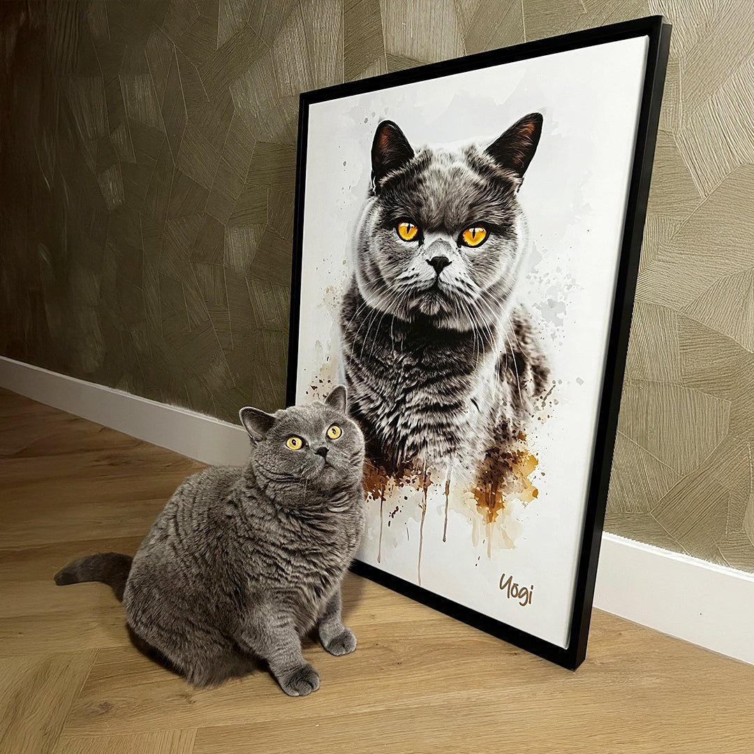 Grijze Britse korthaar zit naast een aquarelportret van zichzelf, gedrukt op canvas met zwarte lijst. Het portret staat schuin tegen een muur op een houten vloer.